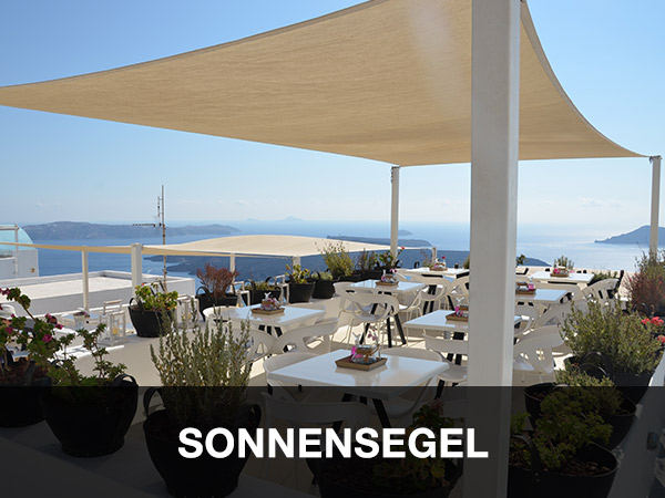 Ein Sonnenschirm, der an eine Anhängerplane erinnert, schützt eine Außenterrasse mit weißen Tischen und Stühlen und bietet einen malerischen Blick auf das Meer und die fernen Hügel. Topfpflanzen schmücken den Bereich unter dem klaren blauen Himmel. Der Text lautet „SONNENSEGEL“.